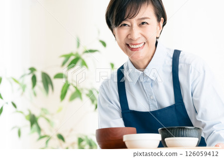Middle-aged woman serving food Middle-aged woman serving food 126059412