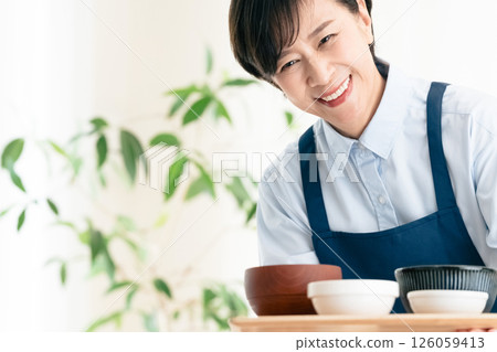 Middle-aged woman serving food Middle-aged woman serving food 126059413