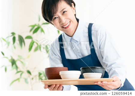 Middle-aged woman serving food Middle-aged woman serving food 126059414