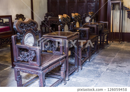 Shanghai, China - 1 April 2025: Artistic banyan root chairs inside He Xu Hall, part of the historic Dianchun Hall in Yuyuan Garden, famous for unique woodwork 126059458