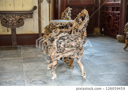 Shanghai, China - 1 April 2025: Intricately carved chairs and table made from banyan roots inside He Xu Hall of Dianchun Hall, Yuyuan Garden Shanghai, China - 1 April 2025: Intricately carved chairs and table made from banyan roots inside He Xu Hall of Dianchun Hall, Yuyuan Garden 126059459