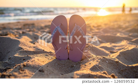 pair of cute slippers out of the sand at the beach at sunset pair of cute slippers out of the sand at the beach at sunset 126059532