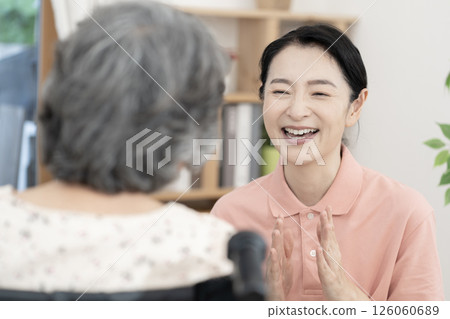A female caregiver talking to a senior woman in a wheelchair A female caregiver talking to a senior woman in a wheelchair 126060689