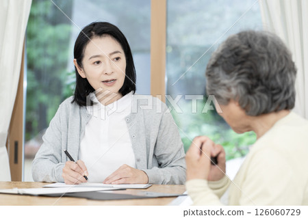Care manager/care manager conducting a home visit 126060729