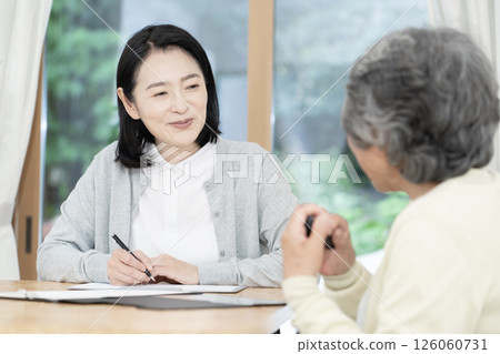 Care manager/care manager conducting a home visit 126060731