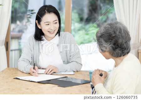 Care manager/care manager conducting a home visit Care manager/care manager conducting a home visit 126060735