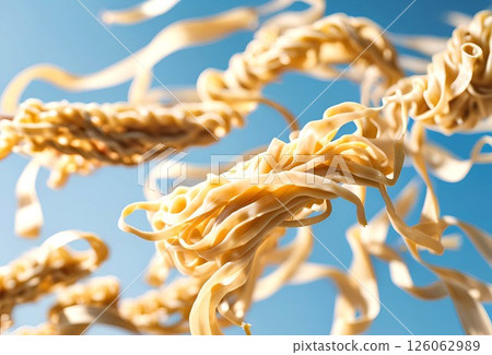 Flat pasta noodles dancing in the blue sky Flat pasta noodles dancing in the blue sky 126062989
