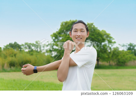 年輕人在公園裡伸展身體 年輕人在公園裡伸展身體 126063109