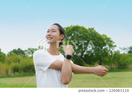 年輕人在公園裡伸展身體 年輕人在公園裡伸展身體 126063110