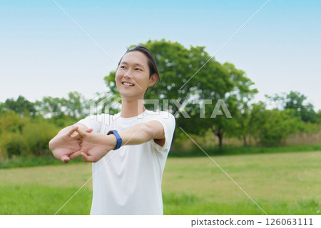 年輕人在公園裡伸展身體 年輕人在公園裡伸展身體 126063111
