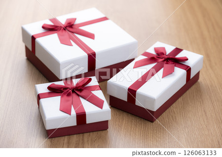 Gift box with red ribbon on wooden table 126063133