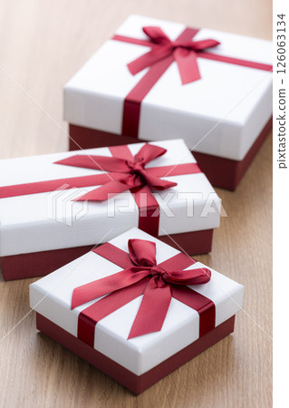 Gift box with red ribbon on wooden table Gift box with red ribbon on wooden table 126063134