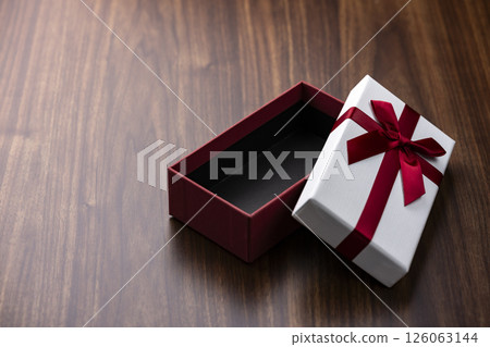 打開有紅色絲帶的禮物盒在木桌上 打開有紅色絲帶的禮物盒在木桌上 126063144