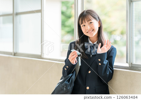A girl in a blazer studying in a school corridor while looking at a vocabulary book A girl in a blazer studying in a school corridor while looking at a vocabulary book 126063484