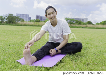 Young man stretching in the park Young man stretching in the park 126063656