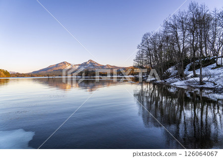 Early summer in Urabandai, Lake Hibara, with trees reflected on the lake surface in the evening and Mt. Bandai 126064067