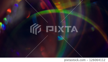 Defocused color reflection. Circling glare. Green blue orange purple kaleidoscope lens flare on blurred bokeh light background. Defocused color reflection. Circling glare. Green blue orange purple kaleidoscope lens flare on blurred bokeh light background. 126064112