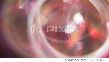 Twirling round. Defocused leak. Colorful pink optical stripes lens flare on blurred bokeh light modern gleam background. Twirling round. Defocused leak. Colorful pink optical stripes lens flare on blurred bokeh light modern gleam background. 126064210