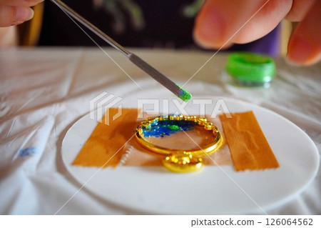 Enjoying making accessories by pouring resin into a mold 126064562