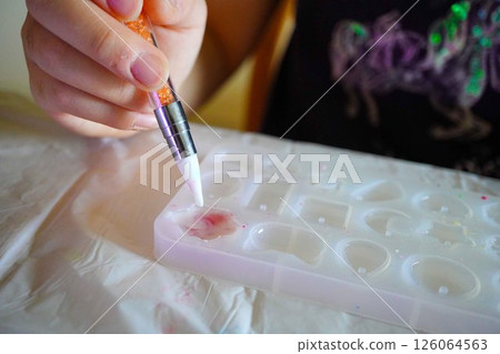 A child enjoying making resin works by pouring resin liquid into a silicon mold A child enjoying making resin works by pouring resin liquid into a silicon mold 126064563
