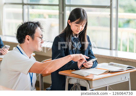 A teacher and a female student teaching using a smartphone (BYOD/ICT) 126064730
