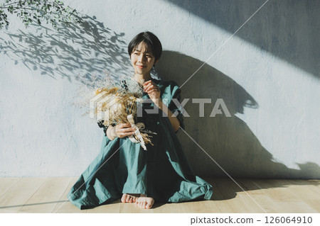 A young woman in a green dress leaning against a wall A young woman in a green dress leaning against a wall 126064910