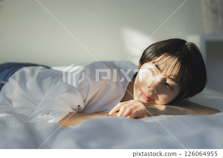 A woman relaxing in bed A woman relaxing in bed 126064955