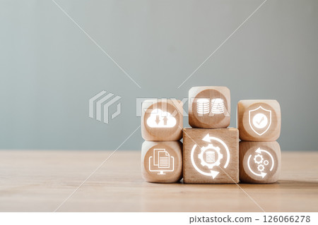 Wooden blocks with icons representing data backup, cloud storage, and security on a wooden surface. 126066278