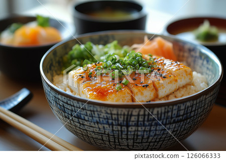 a Japanese kaiseki meal, featuring small, elegantly arranged dishes of sushi, tempura, and miso soup, served on lacquerware with chopsticks and sake cups, under soft ambient lighting 126066333