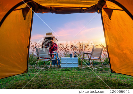 Tourist taking a photo and enjoy nature landscape in front of camping tent. 126066641