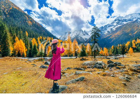 Tourist taking photo of Siguniangshan in autumn, Sichuan in China. 126066684