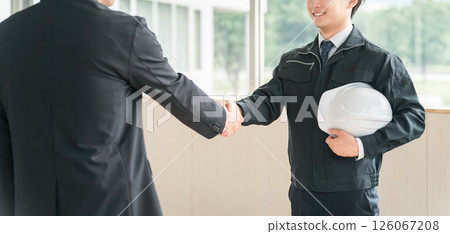 Young Asian men in work clothes shaking hands in a conference room Young Asian men in work clothes shaking hands in a conference room 126067208