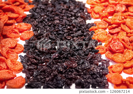 Orange dried apricots and dark raisins isolated on white background top view. Dried fruits background. 126067214