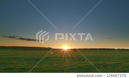 A Stunning and Beautiful Sunrise Over Lush Green Fields Set in a Tranquil Landscape Time lapse. 126067378