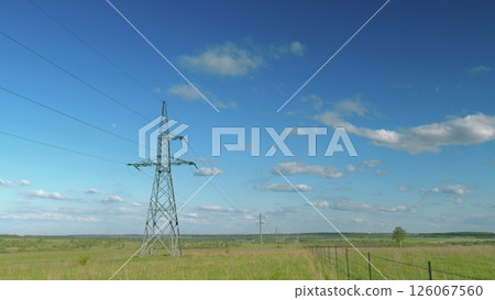 Towering, High Power Lines Stand Out Against a Beautiful Blue Sky with White Clouds Time lapse. 126067560