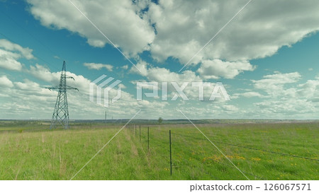 A Serene and Tranquil Landscape Featuring Power Lines Beneath a Sprawling Blue Sky Time lapse. A Serene and Tranquil Landscape Featuring Power Lines Beneath a Sprawling Blue Sky Time lapse. 126067571