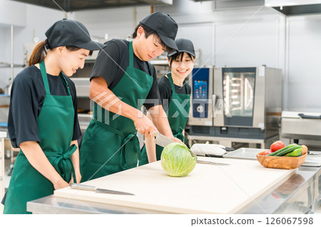 Male and female kitchen staff cutting cabbage in the kitchen 126067598