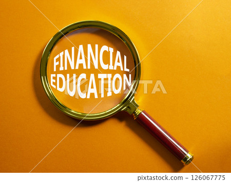 Financial Education symbol. Magnifying Glass with Concept word Financial Education. Beautiful orange background. Business and Financial Education concept. Copy space Financial Education symbol. Magnifying Glass with Concept word Financial Education. Beautiful orange background. Business and Financial Education concept. Copy space 126067775