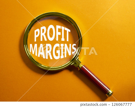 Profit Margins symbol. Magnifying glass with words Profit Margins. Beautiful orange background. Business and Profit Margins concept. Copy space. 126067777