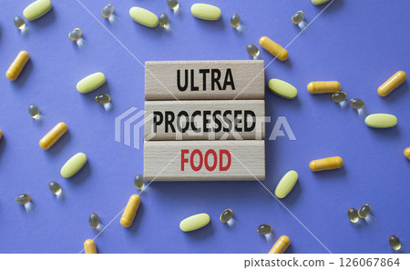 Medicine symbol. Concept words Ultra Processed Food on wooden blocks. Beautiful purple background with pills. Medicine concept and Ultra Processed Food. Copy space Medicine symbol. Concept words Ultra Processed Food on wooden blocks. Beautiful purple background with pills. Medicine concept and Ultra Processed Food. Copy space 126067864