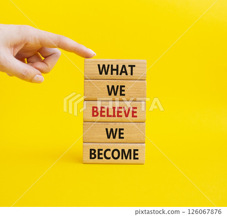 What we Believe we Become symbol. Concept words What we Believe we Become on wooden blocks. Businessman hand. Beautiful yellow background. Business concept. Copy space. 126067876
