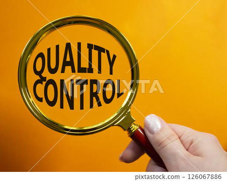 Quality Control symbol. Magnifying glass with words Quality Control. Beautiful orange background. Businessman hand. Business and Quality Control concept. Copy space. Quality Control symbol. Magnifying glass with words Quality Control. Beautiful orange background. Businessman hand. Business and Quality Control concept. Copy space. 126067886