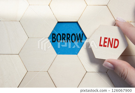 Lend or Borrow symbol. Concept word Lend or Borrow on wooden comb puzzle. Businessman hand. Beautiful blue background. Business and Lend or Borrow concept. Copy space Lend or Borrow symbol. Concept word Lend or Borrow on wooden comb puzzle. Businessman hand. Beautiful blue background. Business and Lend or Borrow concept. Copy space 126067900