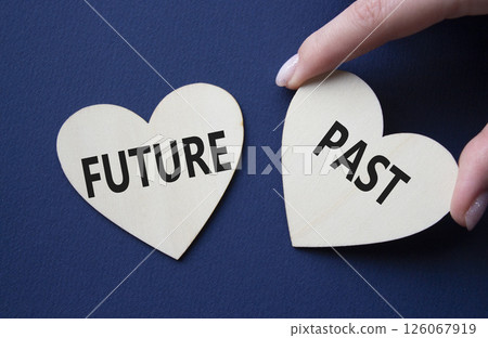 Future or Past symbol. Concept word Future or Past on wooden hearts. Businessman hand. Beautiful deep blue background. Business and Future or Past concept. Copy space Future or Past symbol. Concept word Future or Past on wooden hearts. Businessman hand. Beautiful deep blue background. Business and Future or Past concept. Copy space 126067919