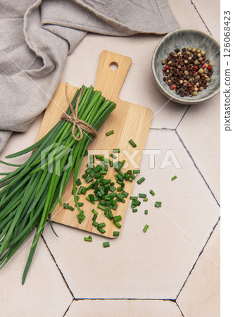 Fresh chives and peppercorns on rustic tile background Fresh chives and peppercorns on rustic tile background 126068423