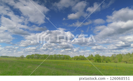 A Beautiful, Lush Green Pasture Spreading Out Endlessly Under a Cloudy Yet Bright Blue Sky Above Time lapse. A Beautiful, Lush Green Pasture Spreading Out Endlessly Under a Cloudy Yet Bright Blue Sky Above Time lapse. 126068551