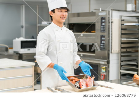 身穿廚師服的男員工正在準備魚(廚師、生鮮市場、食物加工) 身穿廚師服的男員工正在準備魚(廚師、生鮮市場、食物加工) 126068779