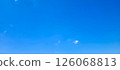 A few clouds floating in a clear blue sky 126068813