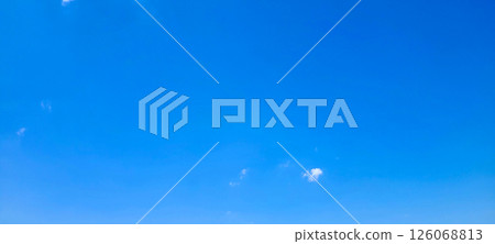 A few clouds floating in a clear blue sky 126068813