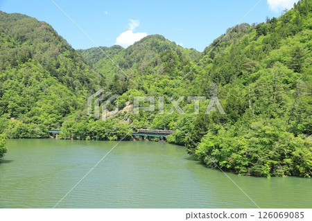 Iida Line local train 18 running along Hiraoka Dam Lake 126069085